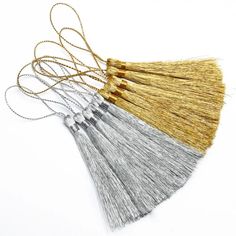 five different colored tassels with gold and silver thread on white background stock photo