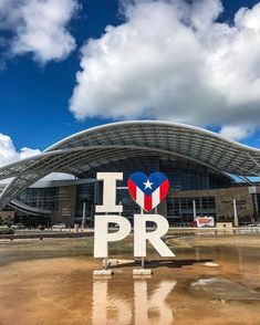 the i love pr sign is in front of a large building with a sky background