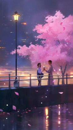 two people standing on a bridge next to a pink tree