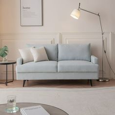 a living room with a couch, table and lamp in it's centerpiece