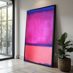 an abstract painting on the wall next to a potted plant in front of a large window