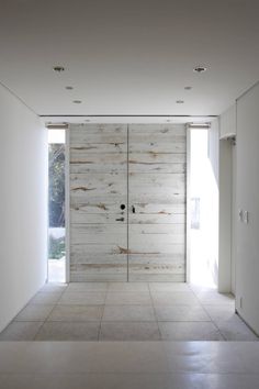 an empty room with white walls and wooden doors