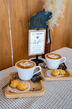 two cups of coffee sitting on top of wooden trays