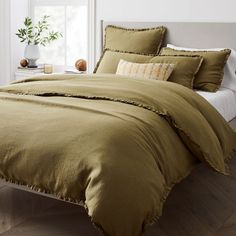 a bed with green sheets and pillows in a room