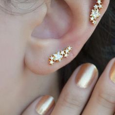 a woman's ear is adorned with gold stars