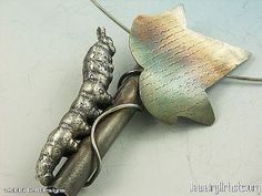 a silver brooch with an image of a fish on it's back end