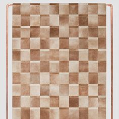 an area rug with squares in brown and beige colors on a white background that appears to be made out of leather