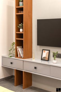 a flat screen tv mounted to the side of a wooden shelf in a living room