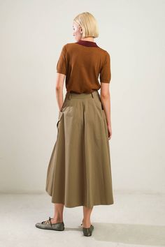 A solid woven full skirt featuring front closure and side pockets Details: Self : 100% Cotton Size & Fit - Model is 5`8" And Wearing Size Small- Measurements Taken From Size Small- Approx. Length: 33.5" Fall Long Khaki Skirt, Khaki Midi Skirt For Fall, Relaxed Khaki Skirt For Fall, Khaki Skirt For Workwear, Workwear Full Skirt With Pockets, Khaki Pleated Midi Skirt, Brown Midi Skirt With Pockets, Khaki Wide Leg Skirt With Pockets, Khaki Cargo Skirt For Workwear