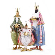 three figurines are standing next to each other on a white surface with one wearing a crown