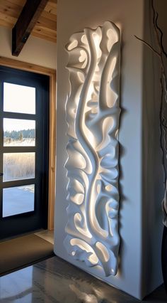 a large white sculpture sitting in the middle of a room next to a door and window