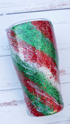 a red, white and green cup sitting on top of a table