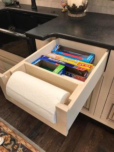 a roll of toilet paper is sitting in the middle of an open drawer on a counter