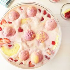 a dessert with strawberries and ice cream in it sitting on a table next to other desserts