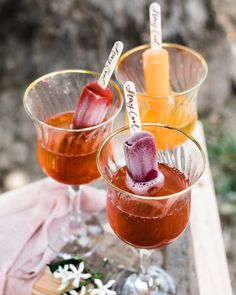 two glasses filled with drinks sitting on top of a table