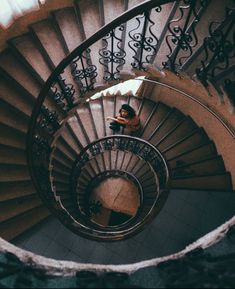 a man sitting on top of a spiral staircase