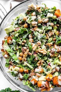 a glass bowl filled with salad and dressing