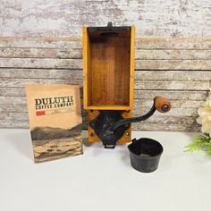 an old fashioned coffee grinder next to a box