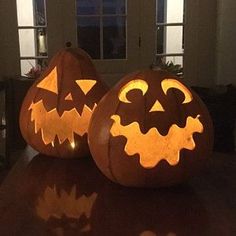 two carved pumpkins sitting on top of a table