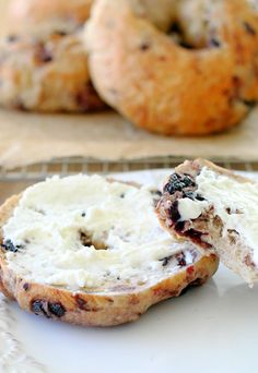 two bagels with blueberries and cream cheese on them