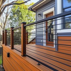 a wooden deck with metal railings next to a house