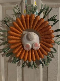 a wreath made out of carrots with a white rabbit on it's back