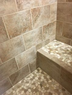 a walk in shower sitting next to a tiled wall and floor covered in circles on it