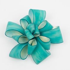 This is part of Chairish’s Costume Jewelry assortment.  This exquisite brooch from Cilea Paris is a piece of art to wear, crafted by hand with skillful attention to detail. Made with high-quality resin, it features a beautiful turquoise ribbon design that creates a stunning visual impact. The brooch is signed with the name "Cilea" on the clasp and is secured with a reliable closing clasp. It is a magnificent statement piece that will impress and make a lasting impression. Measurements: 3.75 in diameter (9.5 cm) x 1.07 in deep (2.7 cm).  Please see the measurements noted above in the description for the best approximate dimensions. Luxury Turquoise Brooches For Gift, Handmade Turquoise Brooches For Gift, Handmade Turquoise Brooches As Gift, Turquoise Resin, Bakelite Brooch, Ribbon Pin, Art To Wear, Ribbon Design, Gold Brooches