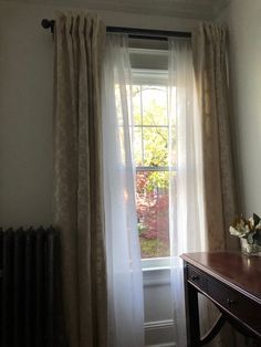 a room with a desk, window and radiator