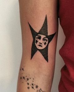 a woman's arm with a star tattoo on it and a face in the middle