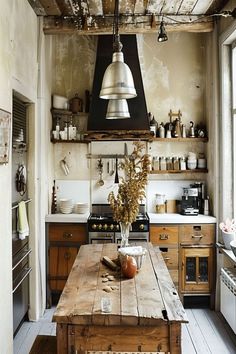 an old fashioned kitchen with wooden table and hanging lights