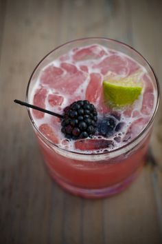 a close up of a drink in a glass with fruit on the rim and garnish