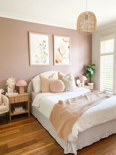 a bed room with a neatly made bed and two pictures on the wall above it