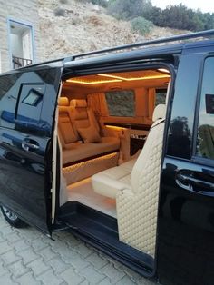 the interior of a black van with its doors open and seats folded down in front of it