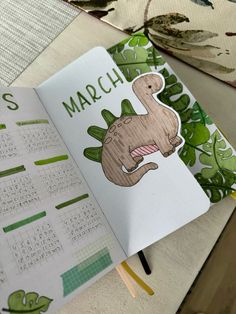 an open calendar book with a dinosaur on it