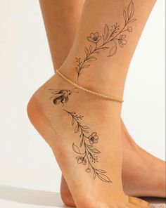 a woman's legs with tattoos and flowers on the side of her leg,