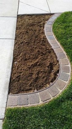 a brick path is in the middle of some grass and mulch on the sidewalk