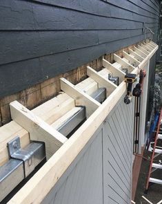 a house being built with wooden boards and ladders attached to the side of it