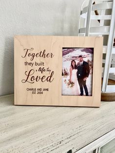 a wooden frame with the words together they built love on it and a photo of a bride and groom