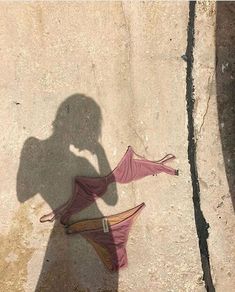 the shadow of a woman's dress and umbrella