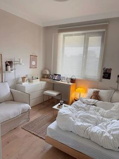 a bed room with a neatly made bed next to a window and a desk in the corner