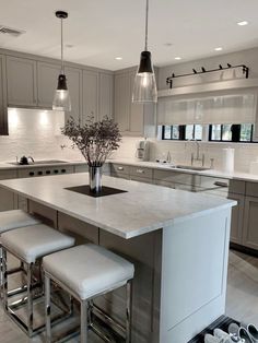 a kitchen island with three stools next to it