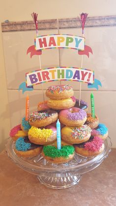 a birthday cake made out of donuts and sprinkles with candles on top