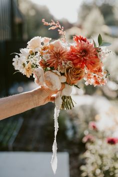 a person holding a bouquet of flowers in their hand