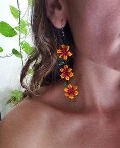 a close up of a woman's neck wearing earrings with small flowers on them