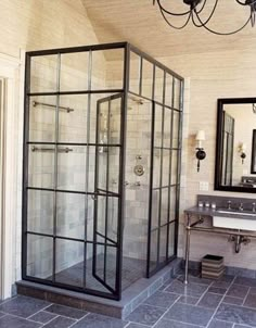 a bathroom with a walk in shower sitting next to a sink and a mirror on the wall