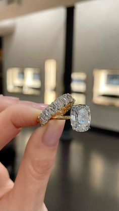 a person holding a diamond ring in their hand