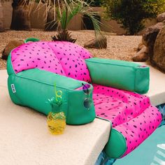 a pink and green bag sitting on top of a pool