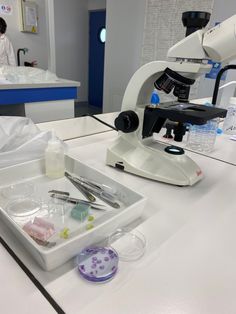 a microscope and some medical supplies on a table in front of a man with a lab coat