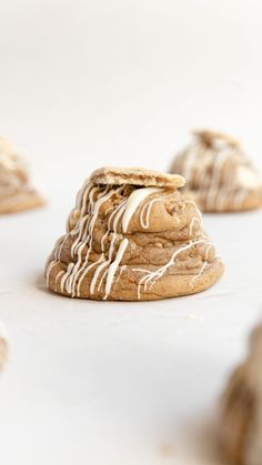 cookies with white icing and drizzled on them sitting on a table